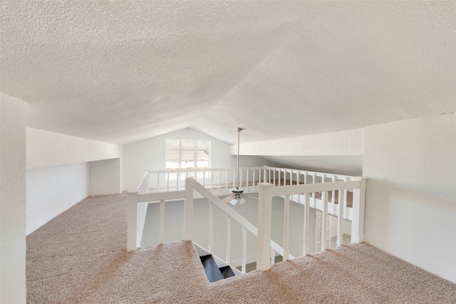 129 Western Ave, Saginaw, TX 76179 - hallway featuring vaulted ceiling, carpet floors, an upstairs landing, and a textured ceiling