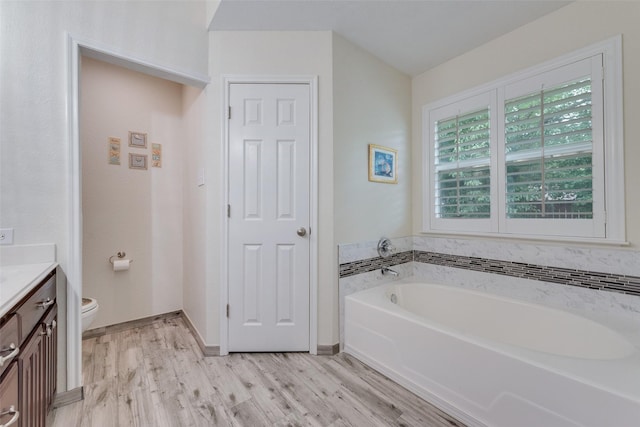 6729 Lucas Ln, North Richland Hills, TX 76182 - full bath with vanity, a garden tub, toilet, wood finished floors, and baseboards