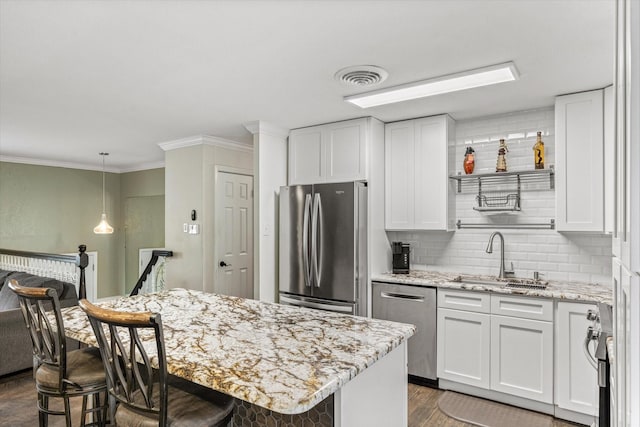 kitchen with stainless steel appliances, a sink, dark wood-style flooring, tasteful backsplash, and white cabinets