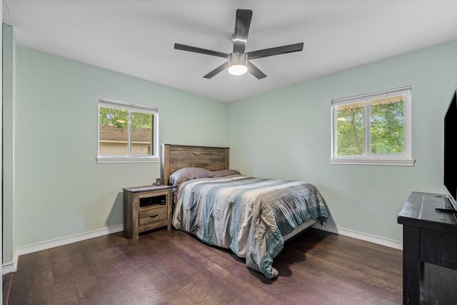 bedroom with dark wood-style floors, baseboards, and ceiling fan