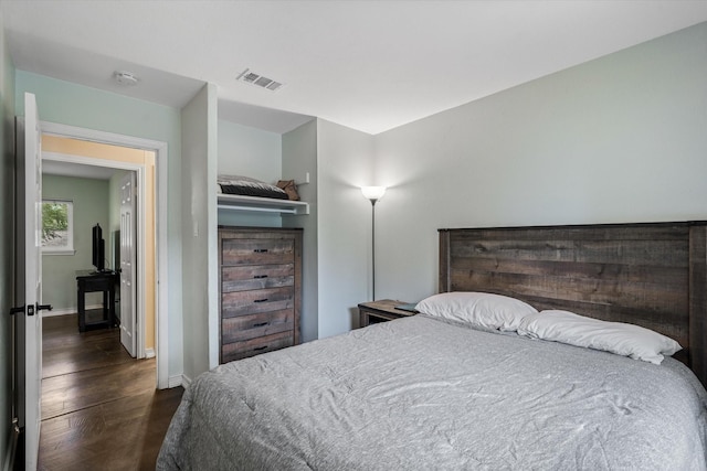 bedroom with dark wood-type flooring and baseboards