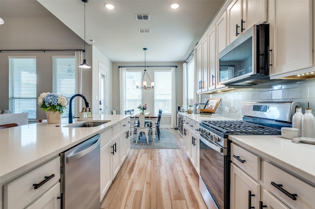 1408 Arrowwood Dr, Aubrey, TX 76227 - kitchen featuring stainless steel appliances, a sink, light wood-style floors, light countertops, and recessed lighting