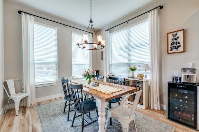 1408 Arrowwood Dr, Aubrey, TX 76227 - dining space with wine cooler, a chandelier, light wood-style floors, and baseboards