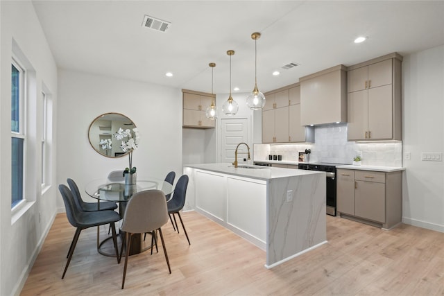 2508 Kool Ave, Dallas, TX 75241 - kitchen with stainless steel range with electric cooktop, gray cabinetry, decorative backsplash, light wood-style floors, and light countertops