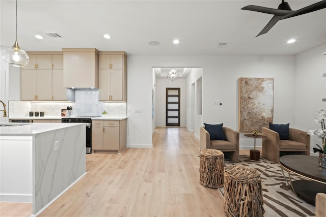 2508 Kool Ave, Dallas, TX 75241 - kitchen with range with electric cooktop, light countertops, tasteful backsplash, light wood finished floors, and decorative light fixtures