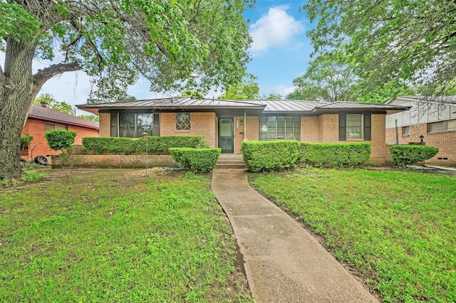 1225 Oak Meadows Dr, Dallas, TX 75232 - view of front of house featuring a standing seam roof, a front lawn, brick siding, and metal roof
