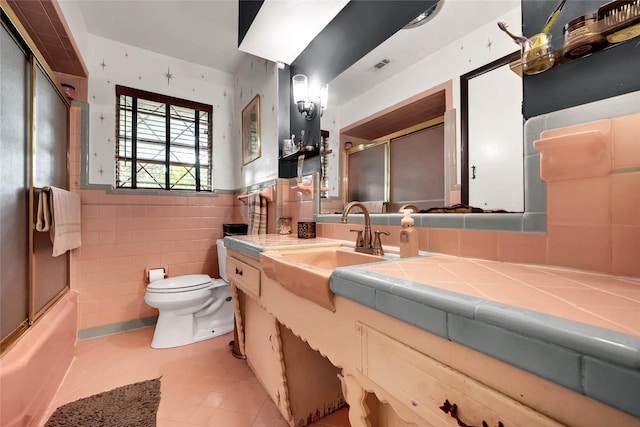 1225 Oak Meadows Dr, Dallas, TX 75232 - bathroom with tile patterned flooring, toilet, vanity, a wainscoted wall, and tile walls