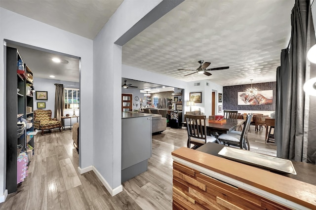 1225 Oak Meadows Dr, Dallas, TX 75232 - dining room with light wood-style flooring, a chandelier, a ceiling fan, and baseboards