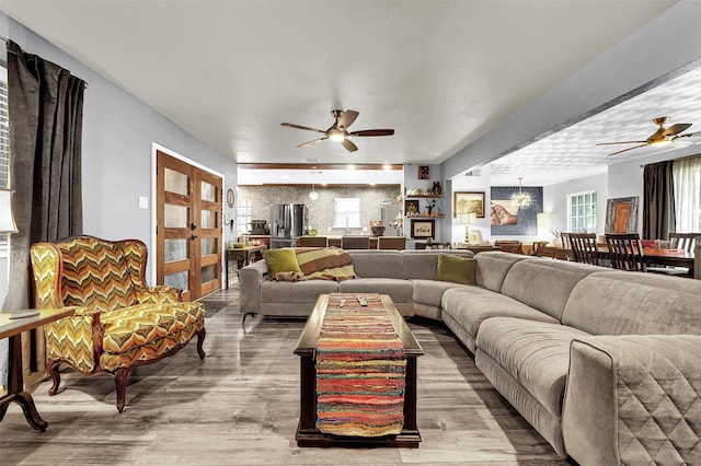 1225 Oak Meadows Dr, Dallas, TX 75232 - living area with ceiling fan, a chandelier, wood finished floors, and an accent wall