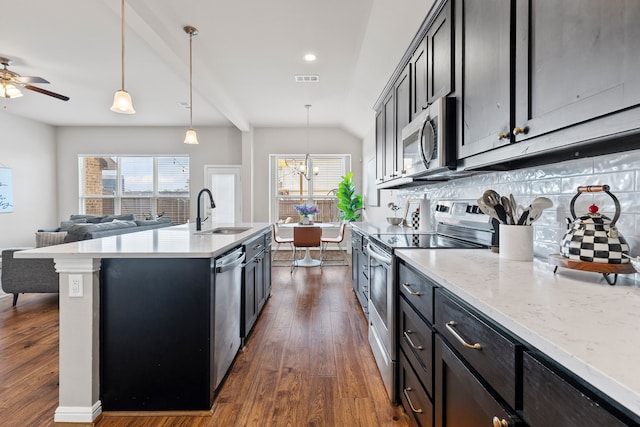 125 Singleton Dr, Royse City, TX 75189 - kitchen with stainless steel appliances, a sink, dark wood finished floors, open floor plan, and vaulted ceiling