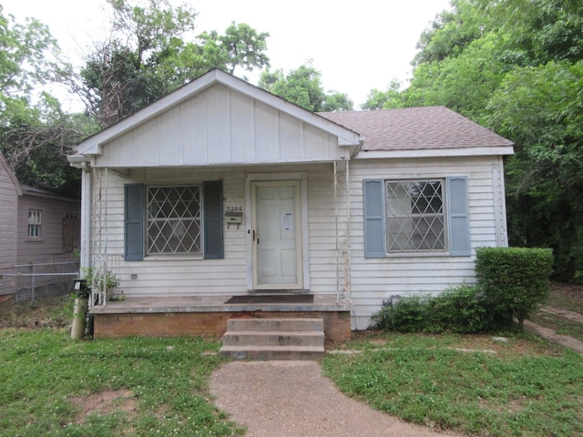 bungalow with fence, roof with shingles, and a porch