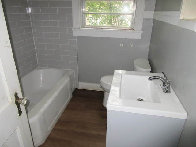 bathroom with wood finished floors, toilet, and vanity