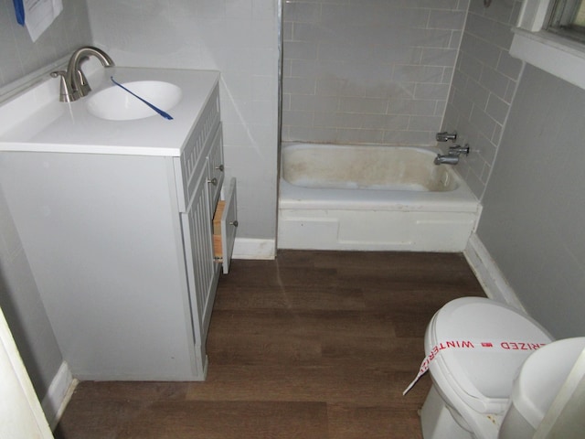 bathroom featuring wood finished floors, bathtub / shower combination, toilet, and vanity