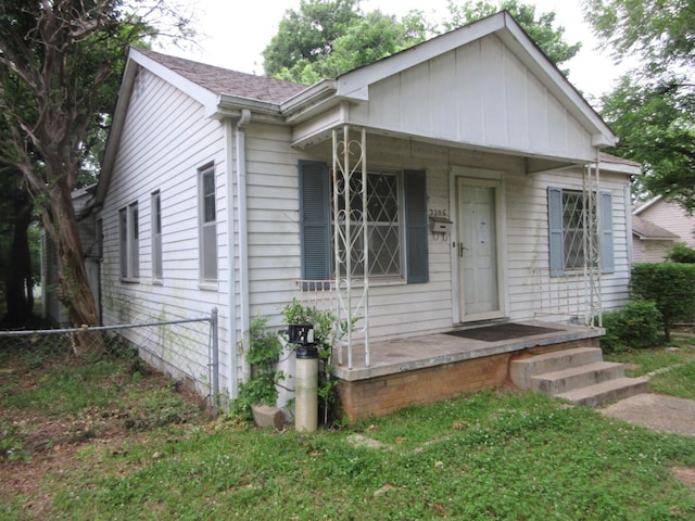 bungalow-style house with fence, a porch, and board and batten siding