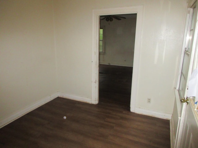 unfurnished room with dark wood finished floors and baseboards