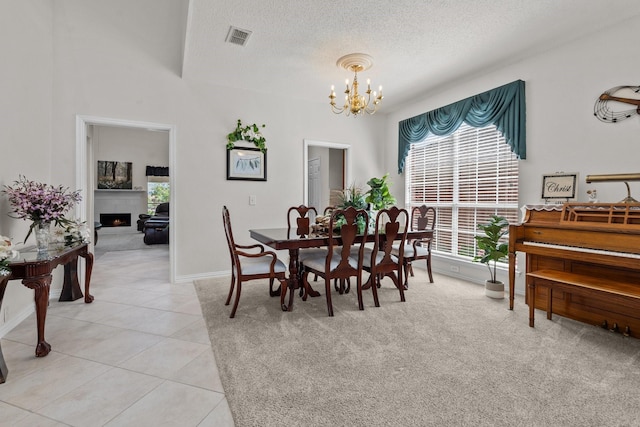 836 Stafford Station Dr, Saginaw, TX 76131 - dining area featuring a chandelier, a textured ceiling, a fireplace, baseboards, and light tile patterned floors