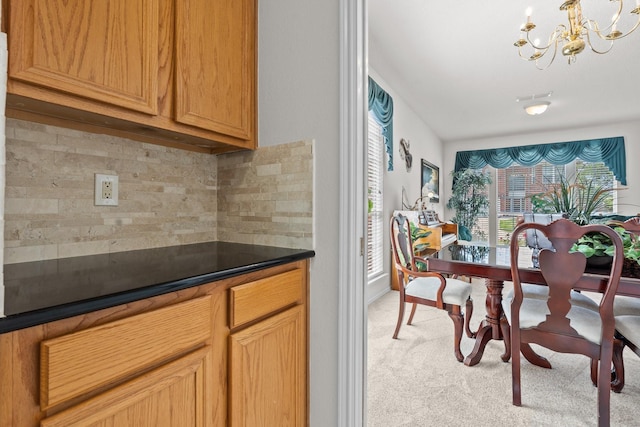 836 Stafford Station Dr, Saginaw, TX 76131 - kitchen with a chandelier, light colored carpet, decorative backsplash, dark countertops, and baseboards