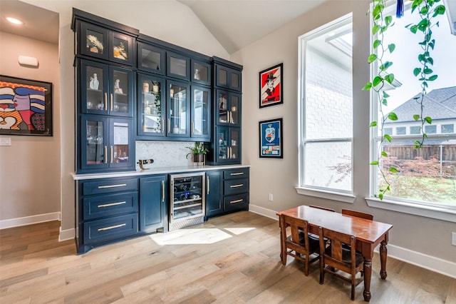 1305 Limestone Ridge Rd, Mansfield, TX 76063 - indoor wet bar with beverage cooler, light wood-style floors, baseboards, lofted ceiling, and backsplash