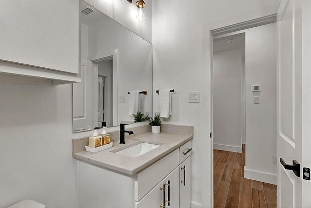 704 Witt, Wolfe City, TX 75496 - bathroom with vanity, wood finished floors, and baseboards