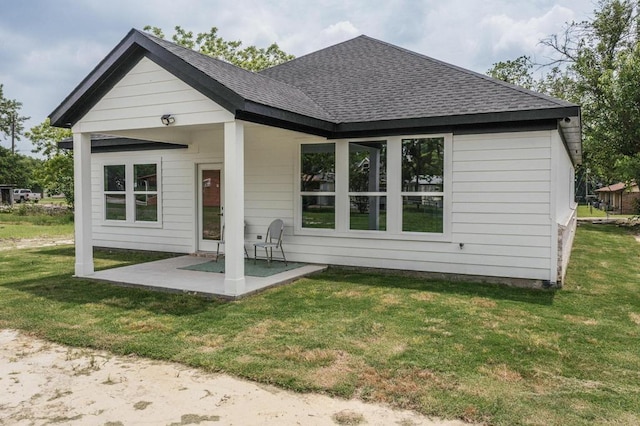 704 Witt, Wolfe City, TX 75496 - view of front facade featuring a shingled roof, a patio, and a front yard