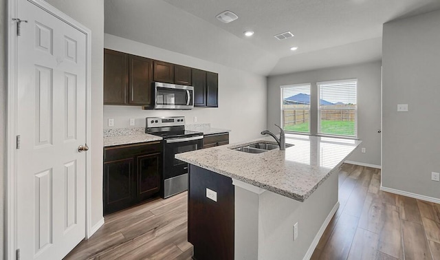 7025 Canadian Dr, Waco, TX 76633 - kitchen with stainless steel appliances, a sink, light wood-style floors, a kitchen island with sink, and baseboards