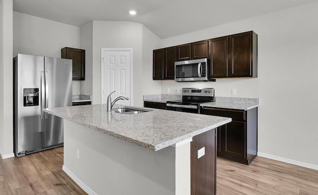 7025 Canadian Dr, Waco, TX 76633 - kitchen with stainless steel appliances, a sink, dark brown cabinetry, baseboards, and light wood-style floors