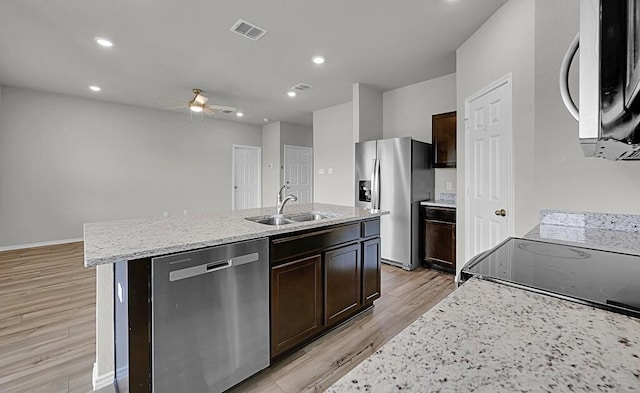 7025 Canadian Dr, Waco, TX 76633 - kitchen featuring appliances with stainless steel finishes, a sink, ceiling fan, light wood finished floors, and dark brown cabinetry