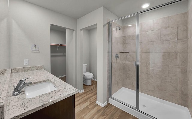 7025 Canadian Dr, Waco, TX 76633 - full bathroom with a shower stall, toilet, wood finished floors, vanity, and a walk in closet