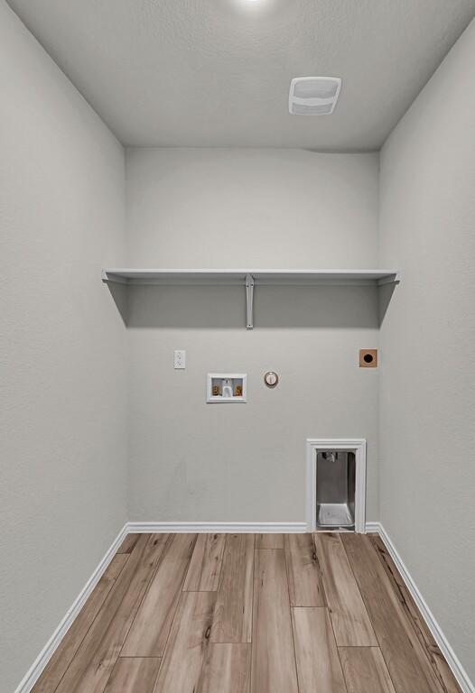 7025 Canadian Dr, Waco, TX 76633 - clothes washing area featuring hookup for an electric dryer, wood finished floors, hookup for a washing machine, gas dryer hookup, and baseboards