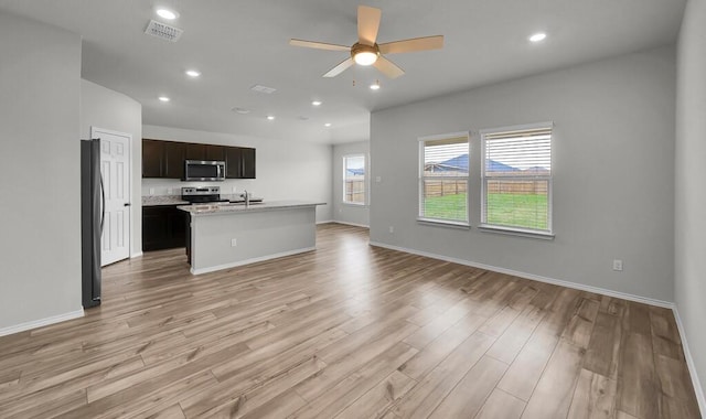 7025 Canadian Dr, Waco, TX 76633 - unfurnished living room featuring a ceiling fan, light wood finished floors, recessed lighting, baseboards, and a sink