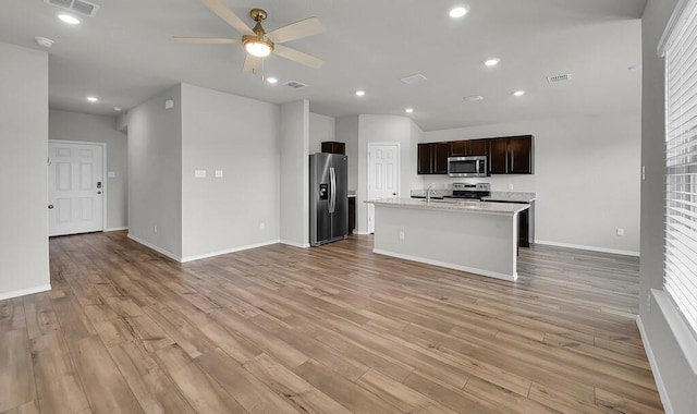7025 Canadian Dr, Waco, TX 76633 - kitchen featuring appliances with stainless steel finishes, open floor plan, a sink, light countertops, and a ceiling fan