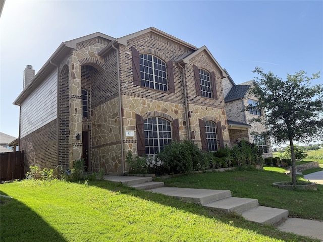 french country inspired facade with brick siding, stone siding, and a chimney