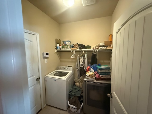 washroom featuring separate washer and dryer and light tile patterned floors