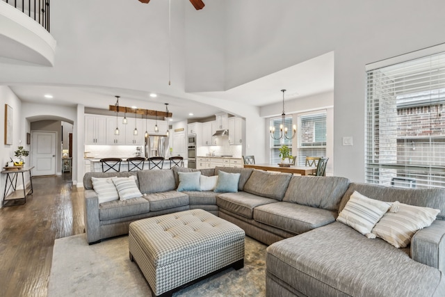 4138 Sanders Dr, Celina, TX 75009 - living room featuring dark wood-style floors, ceiling fan, a chandelier, arched walkways, and recessed lighting