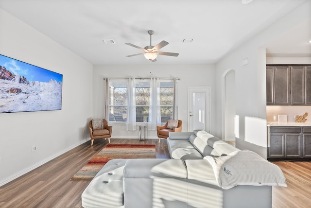 9517 Sunset Ln, Oak Point, TX 75068 - living room featuring light wood-type flooring, ceiling fan, arched walkways, and baseboards