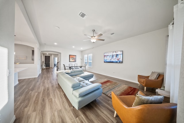 9517 Sunset Ln, Oak Point, TX 75068 - living room featuring arched walkways, a ceiling fan, baseboards, wood finished floors, and recessed lighting