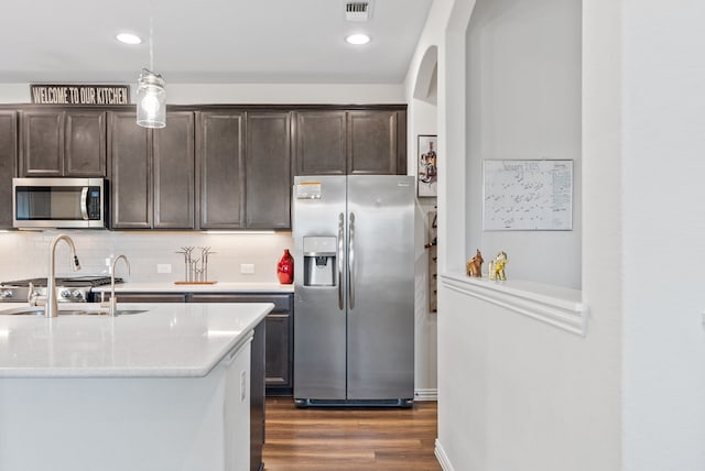 9517 Sunset Ln, Oak Point, TX 75068 - kitchen featuring stainless steel appliances, dark brown cabinetry, a sink, dark wood-style floors, and recessed lighting