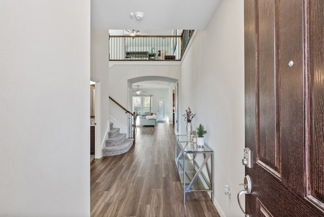 9517 Sunset Ln, Oak Point, TX 75068 - foyer entrance featuring a ceiling fan, arched walkways, wood finished floors, stairway, and a high ceiling