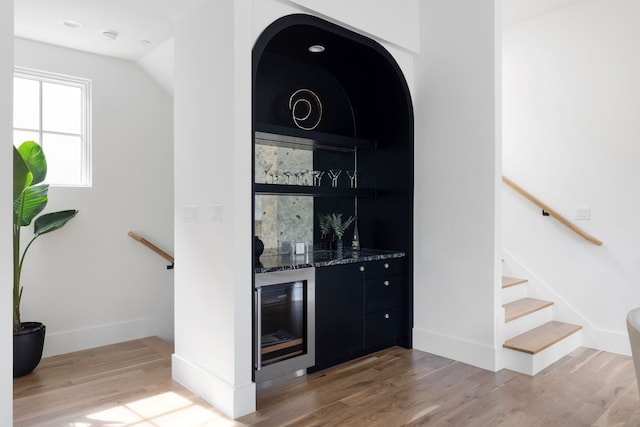 3943 Hawthorne Unit 102, Dallas, TX 75219 - indoor bar with wine cooler, light wood-type flooring, baseboards, and stairway