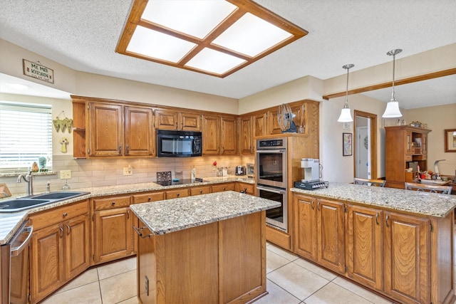 kitchen featuring a sink, black appliances, a peninsula, a center island, and tasteful backsplash