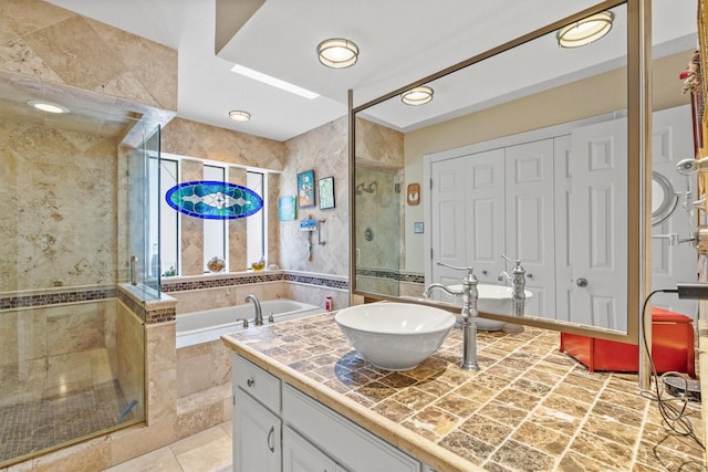 full bathroom featuring a stall shower, a bath, and vanity