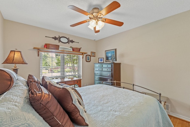 bedroom with wood finished floors, a ceiling fan, and baseboards