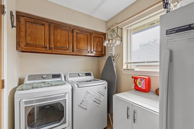 laundry area featuring washing machine and clothes dryer and cabinet space