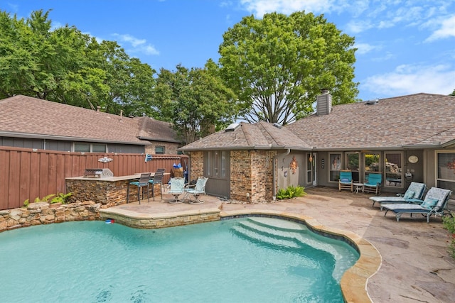 view of pool featuring a fenced backyard, a patio area, and an outdoor kitchen