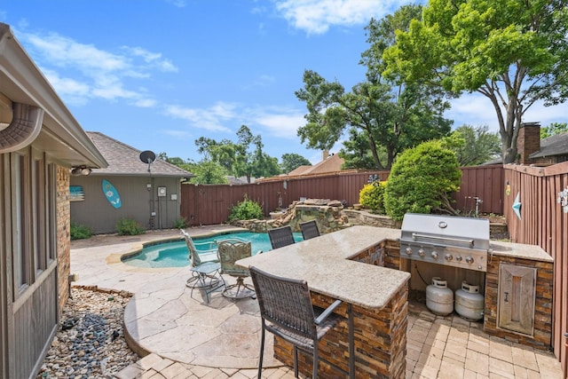 view of patio featuring exterior kitchen, a fenced backyard, and grilling area