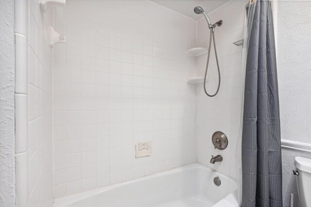 4400 Boston Dr, Plano, TX 75093 - bathroom with shower / tub combo, a textured wall, and toilet