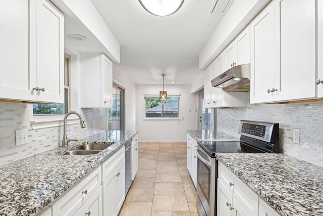 4400 Boston Dr, Plano, TX 75093 - kitchen with under cabinet range hood, stainless steel appliances, a sink, tasteful backsplash, and white cabinets
