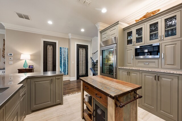 1532 Main St, Southlake, TX 76092 - kitchen featuring crown molding, gray cabinets, glass insert cabinets, beverage cooler, and light wood-style floors