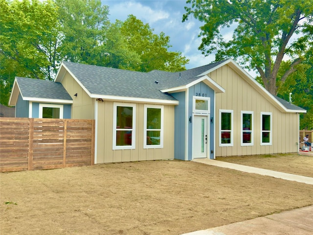 3801 Carpenter Ave, Dallas, TX 75210 - view of front of house featuring fence, roof with shingles, and board and batten siding