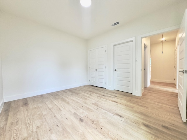 3801 Carpenter Ave, Dallas, TX 75210 - unfurnished bedroom with light wood finished floors, baseboards, and a closet